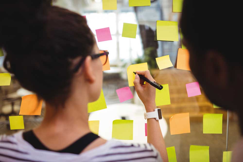 team-member-writing-sticky-notes